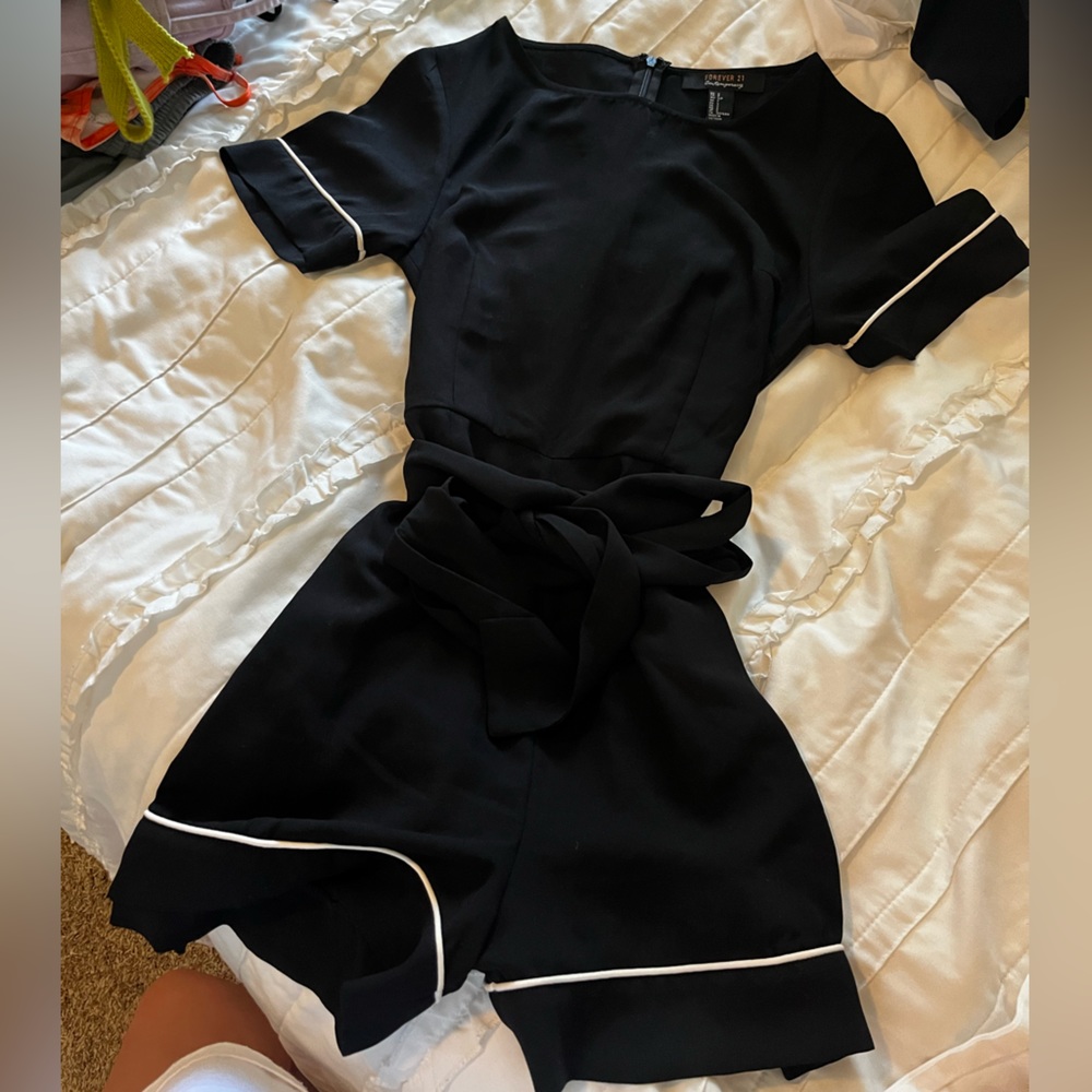 Black cap sleeve romper with white trip and a black bow waist.
